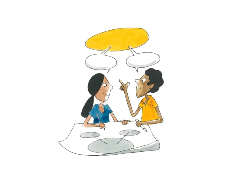 Two learners sharing ideas under a yellow speech bubble